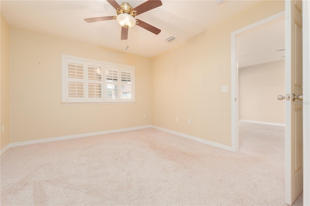 carpeted spare room featuring ceiling fan