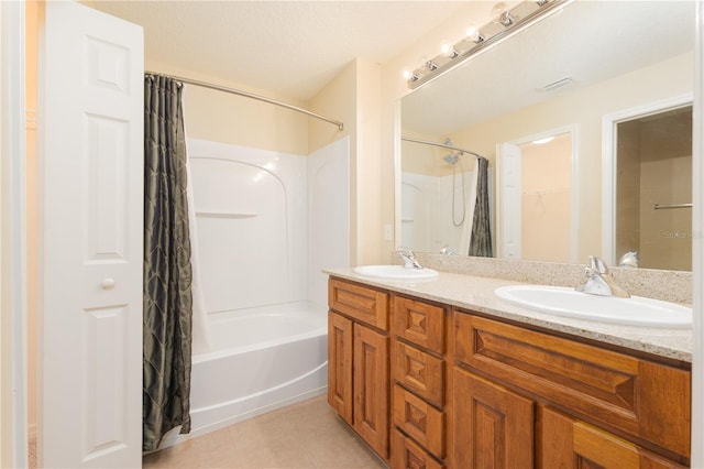 bathroom with vanity, a textured ceiling, tile patterned flooring, and shower / tub combo