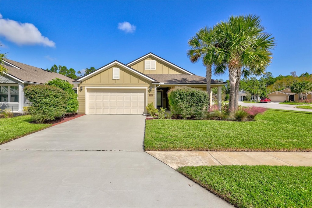 view of front of home with a front yard and a garage