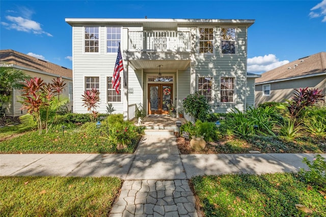 view of front of home featuring a balcony and french doors