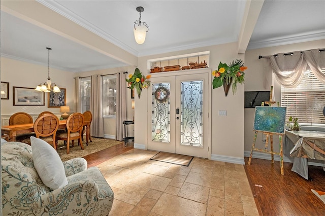 entrance foyer featuring french doors, a wealth of natural light, and ornamental molding