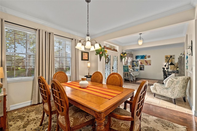 dining space with hardwood / wood-style flooring, a notable chandelier, and crown molding