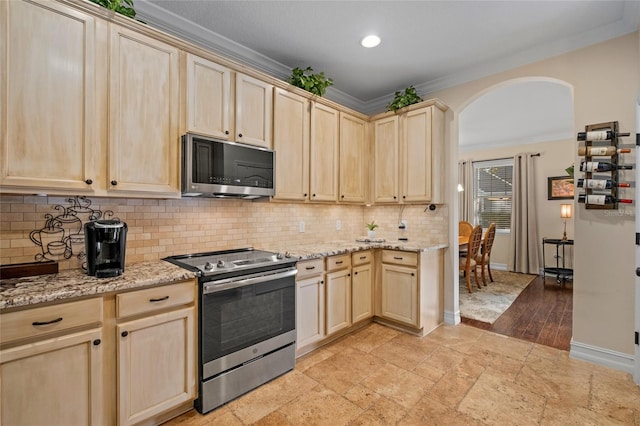 kitchen with light brown cabinetry, stainless steel appliances, light stone counters, and ornamental molding