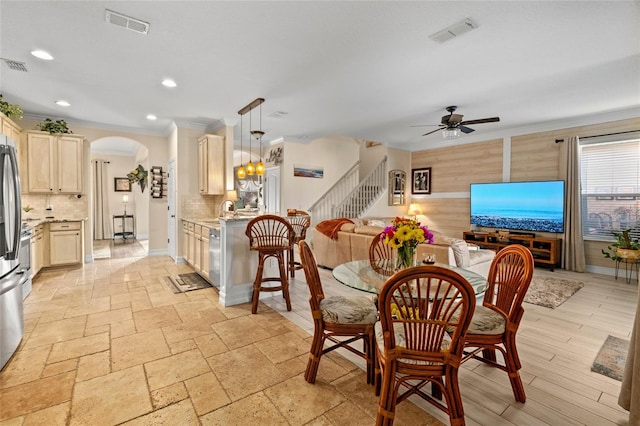 dining area featuring sink, ceiling fan with notable chandelier, and ornamental molding