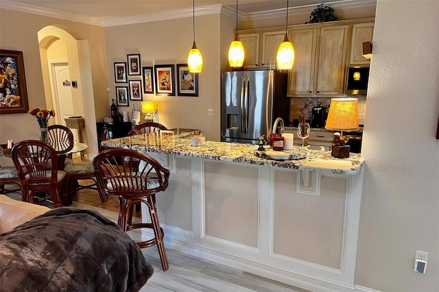 kitchen with light stone counters, a breakfast bar, pendant lighting, and appliances with stainless steel finishes