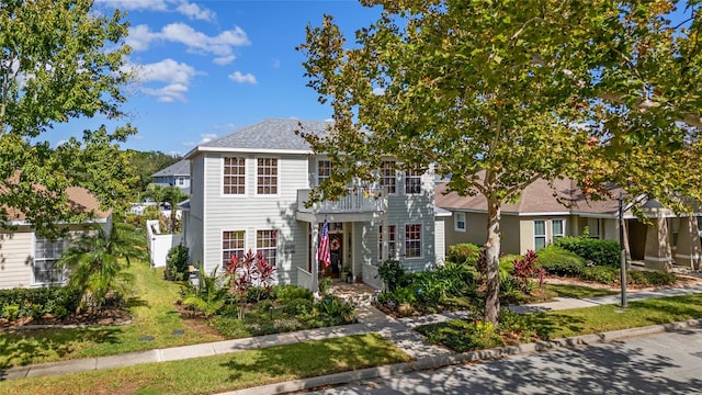 view of front of house with a front yard and a balcony