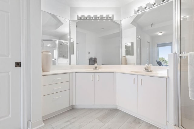 bathroom featuring hardwood / wood-style floors, walk in shower, and vanity