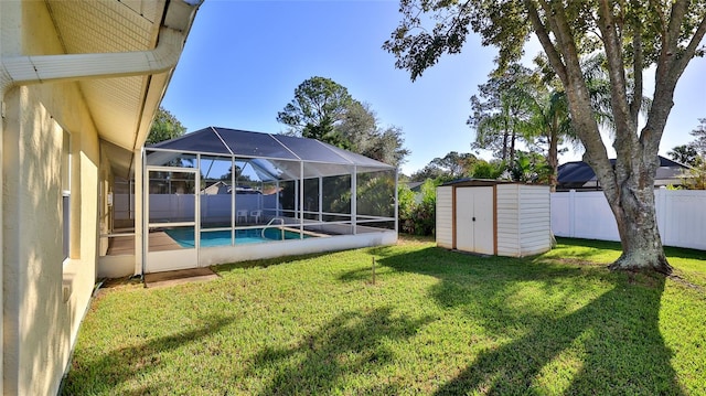 view of yard with a fenced in pool, an outbuilding, a storage unit, a lanai, and a fenced backyard