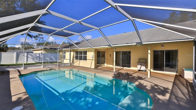 view of swimming pool with ceiling fan, a patio area, and a lanai