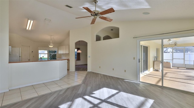 unfurnished room with ceiling fan, light wood-type flooring, visible vents, and baseboards