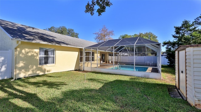 back of house with an outbuilding, stucco siding, a lawn, a storage shed, and glass enclosure