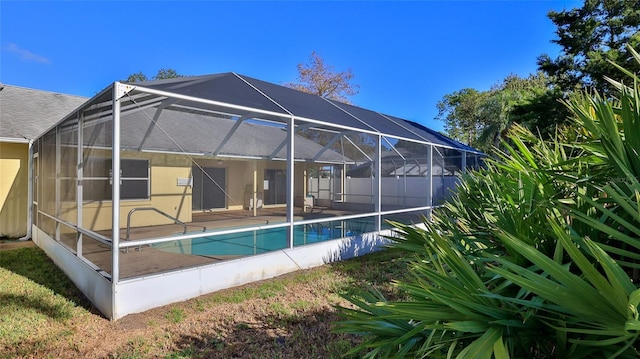 back of house with a fenced in pool, glass enclosure, and a patio