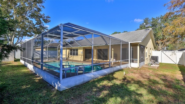 back of property featuring a fenced in pool, a yard, central air condition unit, a lanai, and a fenced backyard