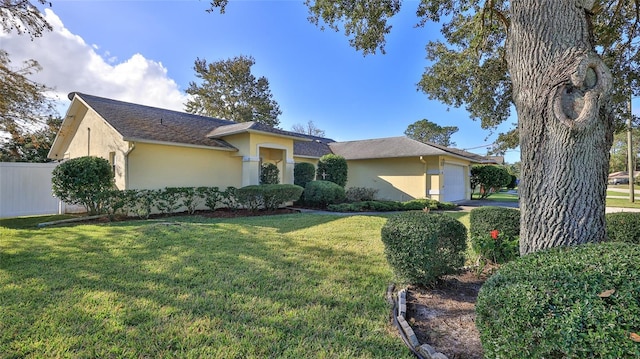 view of front of home with a garage, a front lawn, fence, and stucco siding