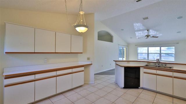 kitchen with black dishwasher, lofted ceiling, light countertops, visible vents, and a sink