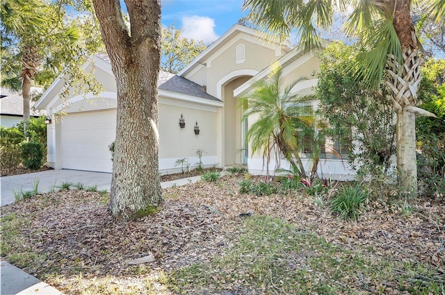 32 Shinnecock Dr, Palm Coast, FL 32137 - view of front of property with stucco siding, a garage, driveway, and a shingled roof