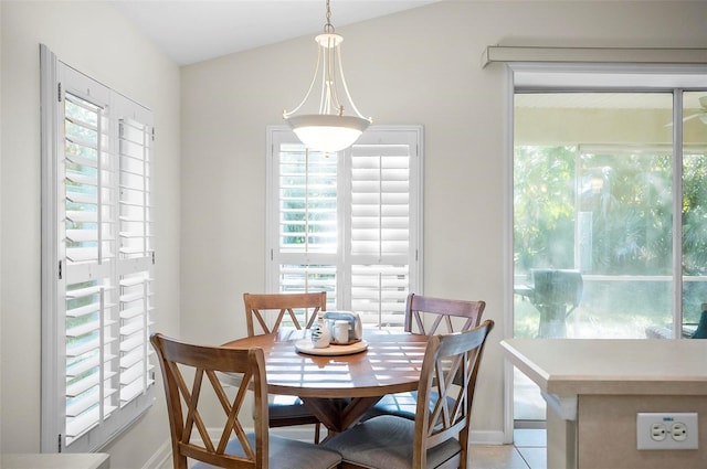 dining space with light tile patterned floors, vaulted ceiling, and a wealth of natural light