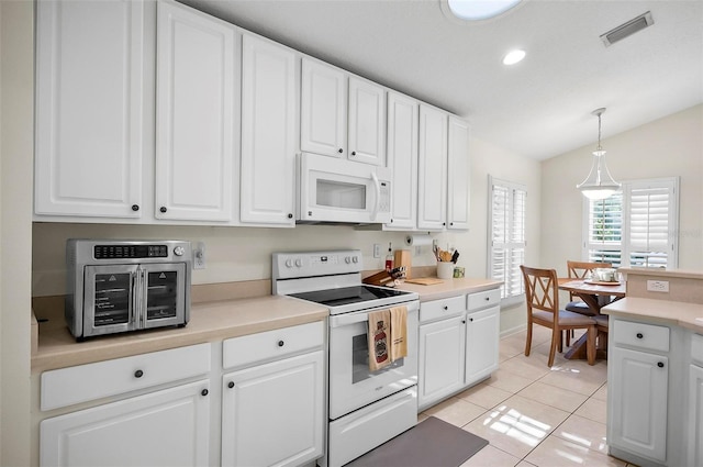 kitchen featuring lofted ceiling, white cabinetry, decorative light fixtures, and white appliances