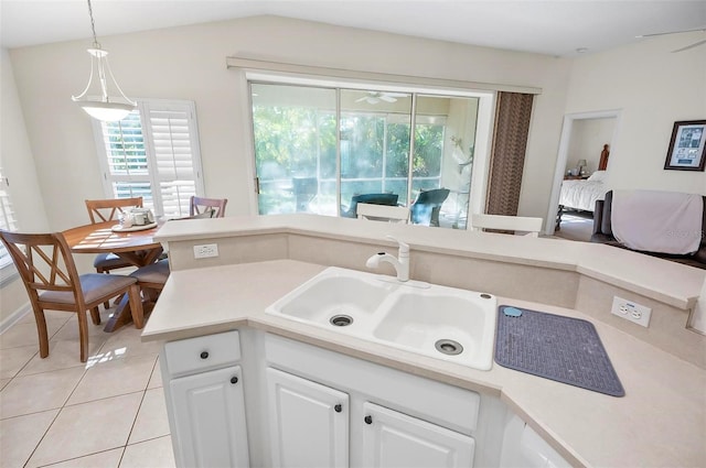 32 Shinnecock Dr, Palm Coast, FL 32137 - kitchen featuring a sink, light tile patterned floors, white cabinetry, light countertops, and hanging light fixtures