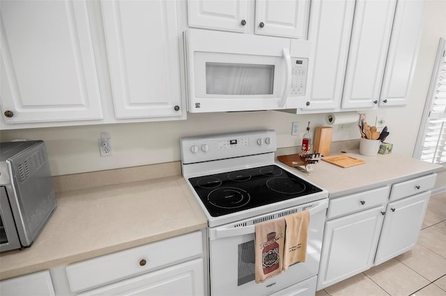32 Shinnecock Dr, Palm Coast, FL 32137 - kitchen featuring white appliances, white cabinets, light tile patterned flooring, and light countertops