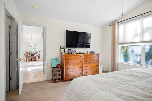 carpeted bedroom with lofted ceiling