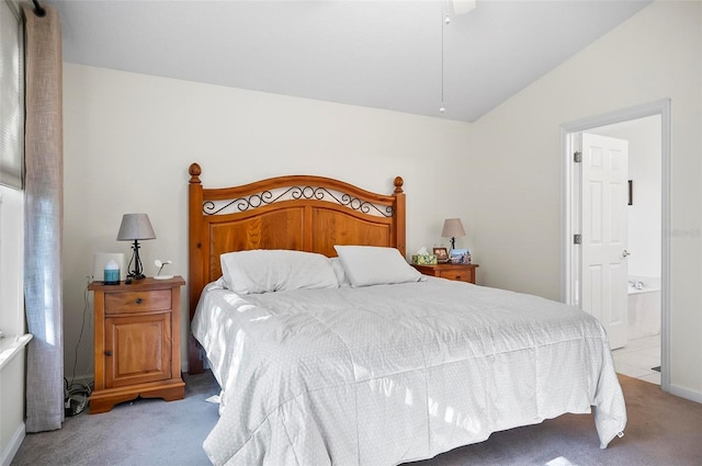 bedroom featuring connected bathroom, vaulted ceiling, and light carpet