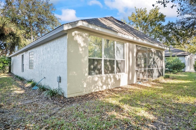 view of property exterior featuring a yard and a sunroom