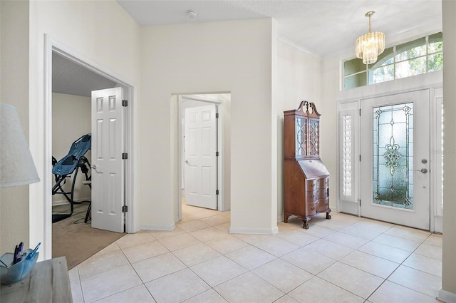 tiled foyer featuring a high ceiling and an inviting chandelier