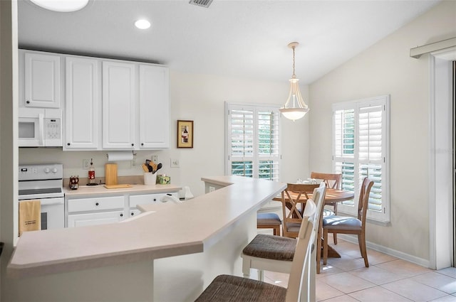 32 Shinnecock Dr, Palm Coast, FL 32137 - kitchen featuring white appliances, white cabinetry, hanging light fixtures, light countertops, and a breakfast bar area