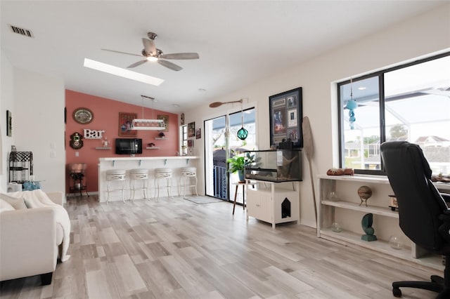 interior space with vaulted ceiling, indoor bar, ceiling fan, and plenty of natural light