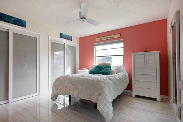 bedroom featuring light hardwood / wood-style floors, a textured ceiling, and ceiling fan