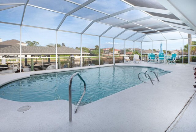 view of swimming pool featuring a lanai and a patio area