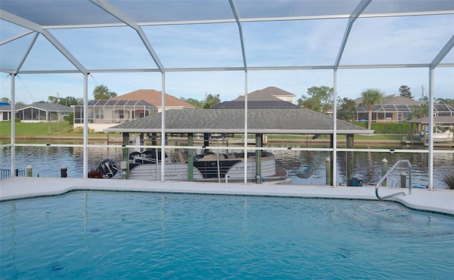 view of pool with a water view, glass enclosure, and a dock