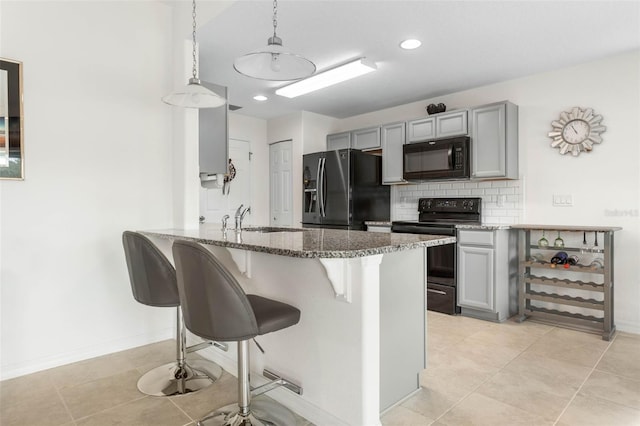 kitchen with black appliances, gray cabinetry, decorative light fixtures, sink, and kitchen peninsula