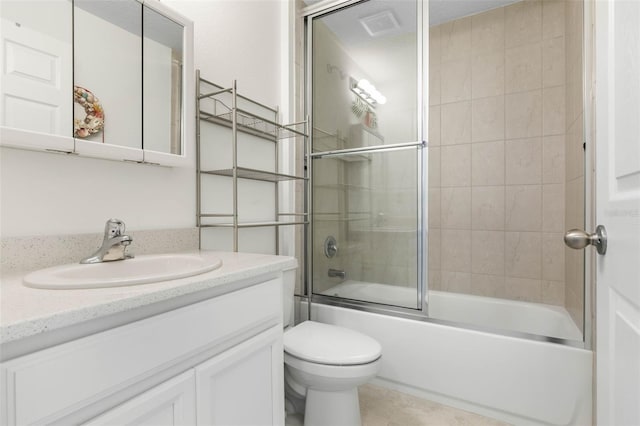 full bathroom featuring toilet, vanity, tile patterned flooring, and enclosed tub / shower combo