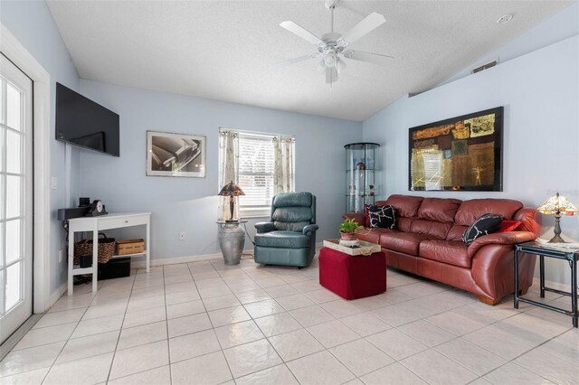 tiled living room with lofted ceiling, a textured ceiling, ceiling fan, and plenty of natural light