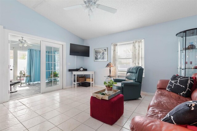 tiled living room featuring ceiling fan, lofted ceiling, a textured ceiling, and a healthy amount of sunlight