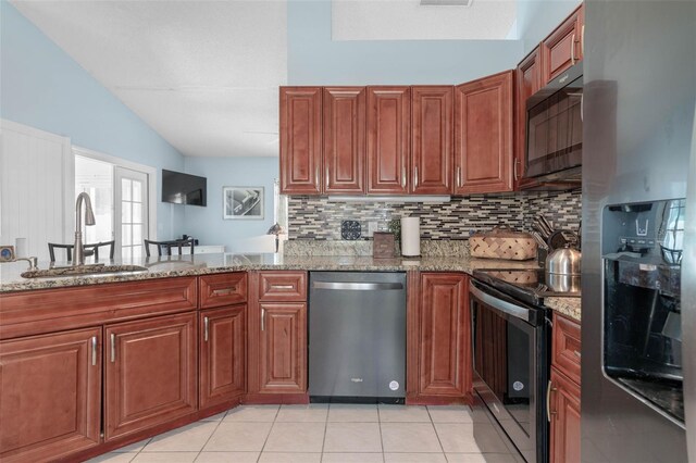 kitchen featuring tasteful backsplash, stainless steel appliances, light tile patterned floors, light stone countertops, and sink