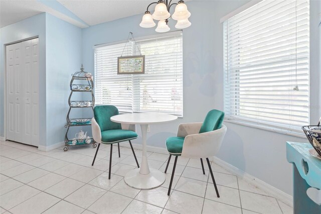 living area featuring light tile patterned flooring, a healthy amount of sunlight, and an inviting chandelier