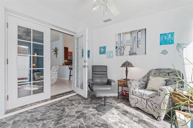 sitting room with ceiling fan and french doors