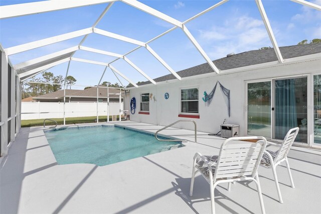 view of swimming pool featuring a patio area and a lanai