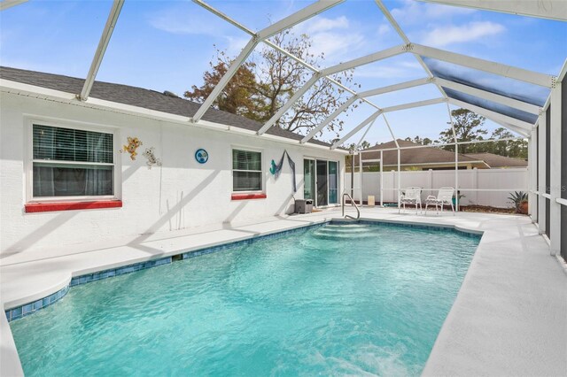 view of swimming pool featuring glass enclosure and a patio area