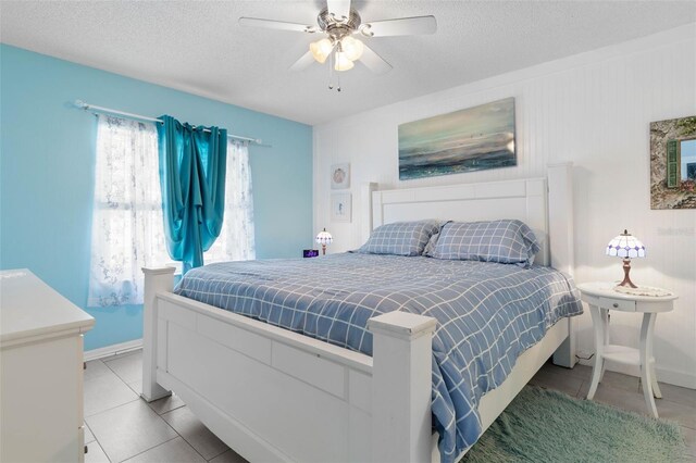 tiled bedroom with a textured ceiling and ceiling fan