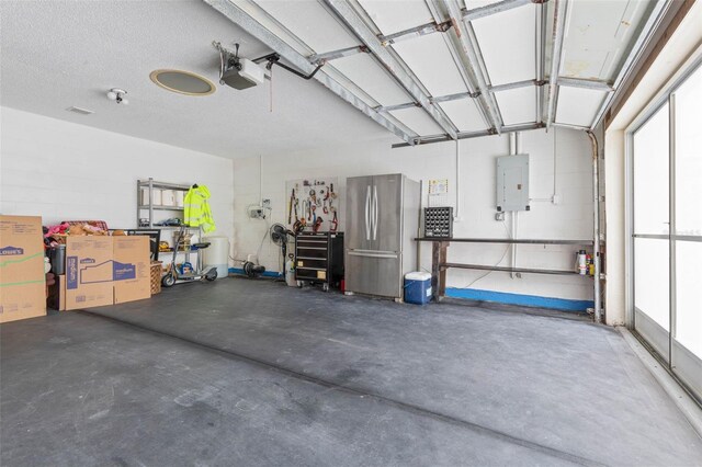 garage with a garage door opener, electric panel, and stainless steel fridge