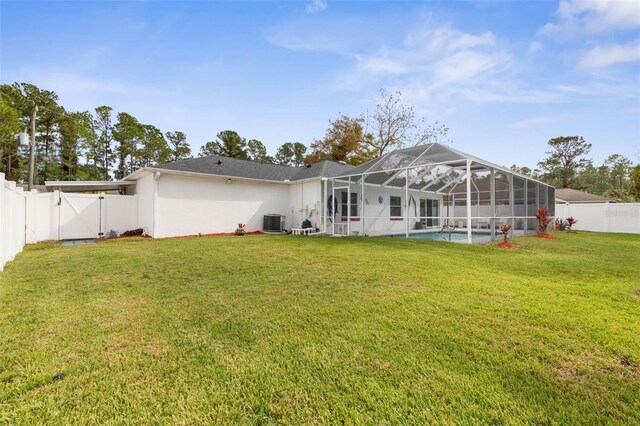 rear view of house featuring a yard, a fenced in pool, central AC, and glass enclosure