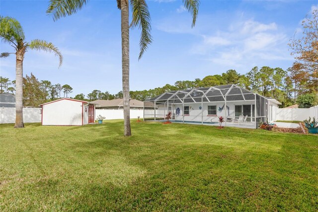 back of property with glass enclosure, a lawn, and a fenced in pool