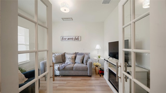 living room with light wood-type flooring and french doors