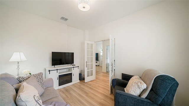 living room featuring french doors and light hardwood / wood-style floors