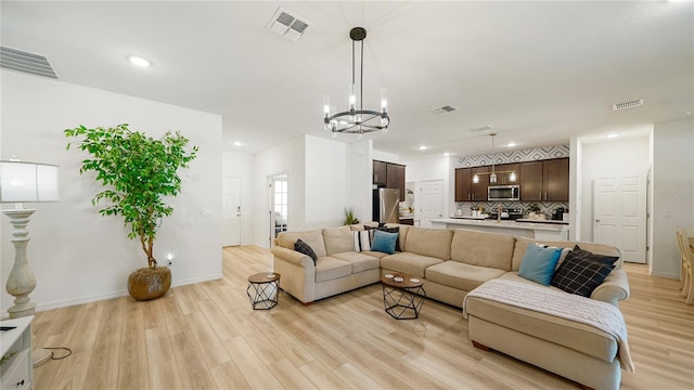 living room with a chandelier and light hardwood / wood-style flooring