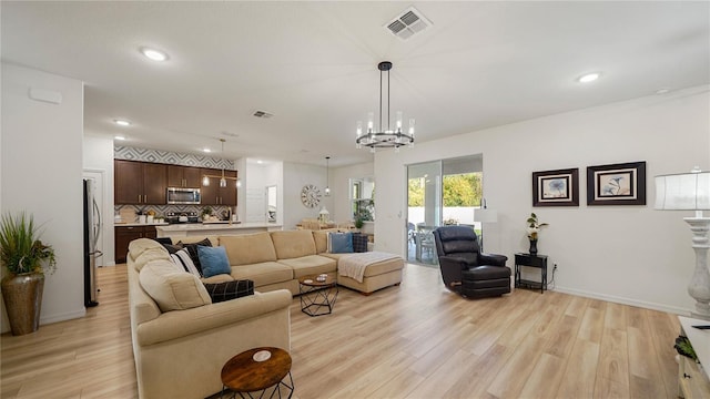 living room featuring light hardwood / wood-style floors and an inviting chandelier